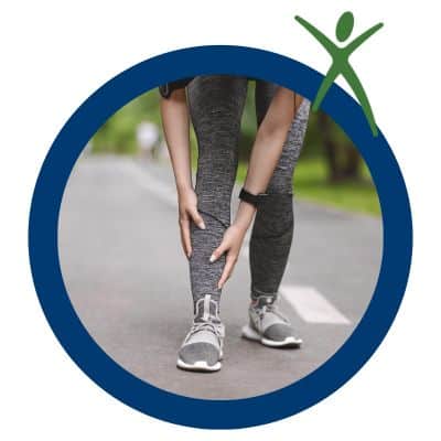 5 tips for avoiding shin splints on your run 3 Person massaging shin while on a run