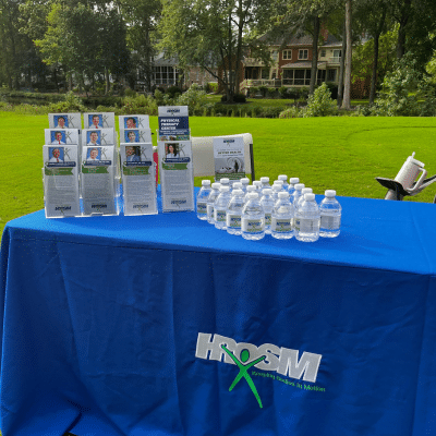 Teeing up for a cause: dr. Jon swenson and hrosm support breast cancer awareness at the annual “tee off for a cure” ladies tournament 4 Hrosm's table at the teeing up for a cause event, representing breast cancer awareness